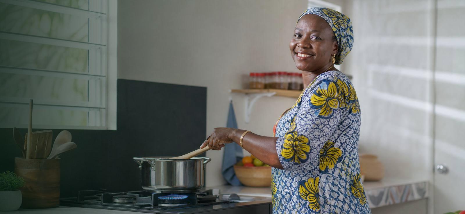 A woman cooking on a clean gas flame in a bright kitchen